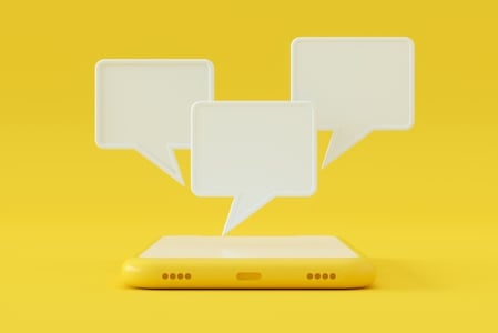 Grafik mit einem Smartphone und Sprechblasen als Symbol für WhatsApp Business