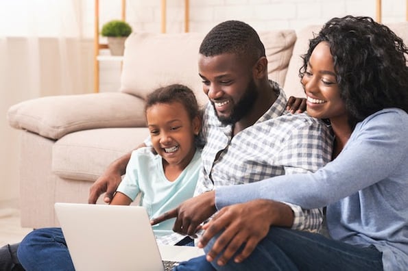 Family sitting on a couch exploring the best WordPress RSS feed plugin options for their blog. 