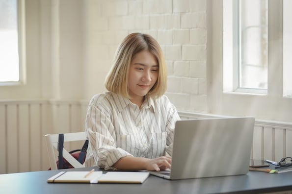 woman using a laptop computer to learn about the CSS transform property