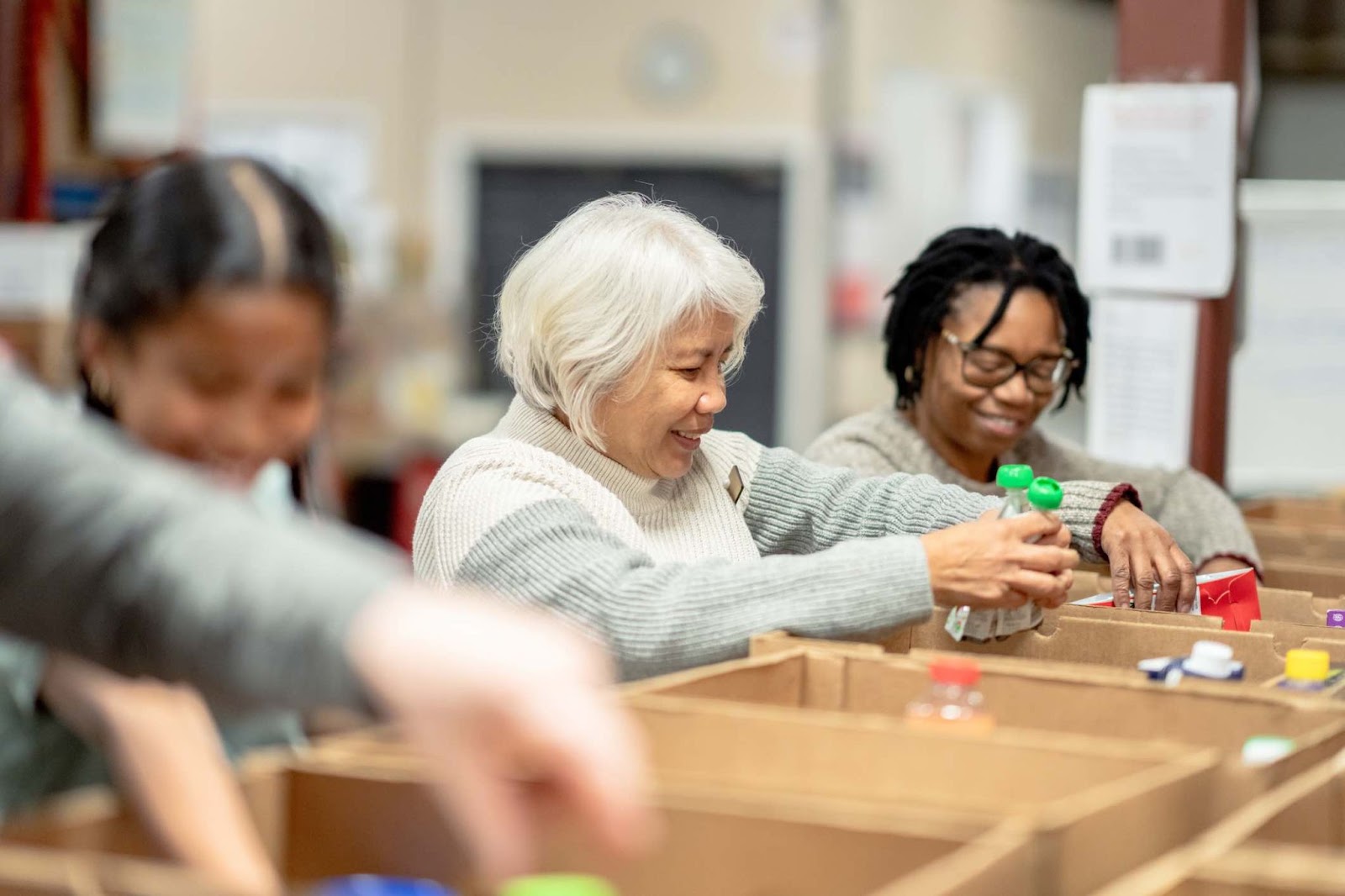 Image shows nonprofit volunteers putting supplies into boxes.