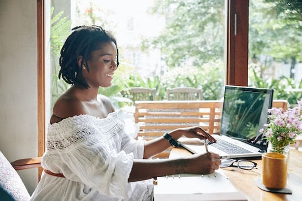 woman sitting at a desk using a laptop to build an API integration