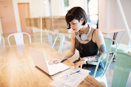 person working on API automation on a laptop in a cafe