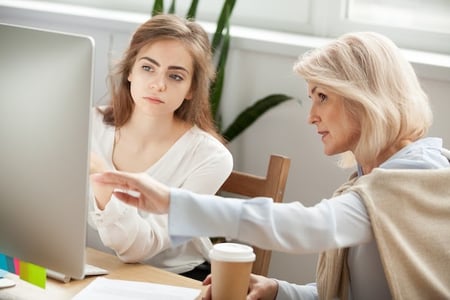 two women using a computer in an office to create a web slideshow