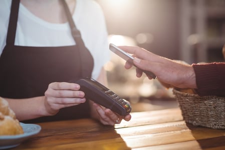 Customer paying bill through smartphone using NFC technology in cafe.jpeg