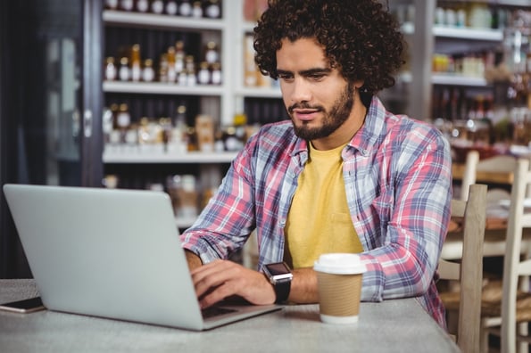 Man using laptop in cafeteria