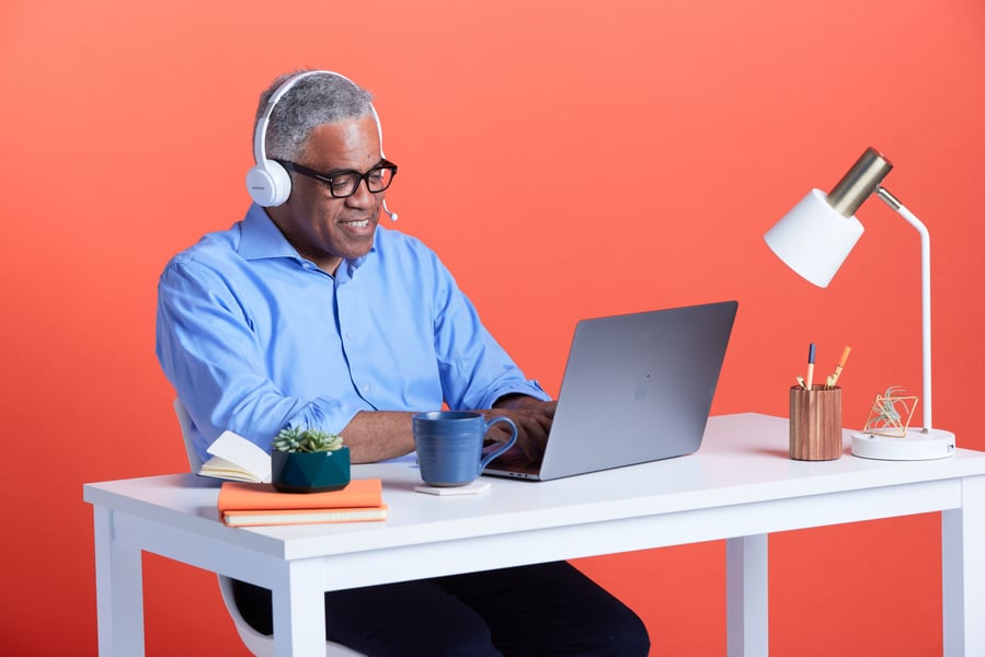 Professional with headset looking at laptop