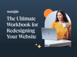 Woman with long dark hair wearing a bright yellow sweater, sitting at a desk with a laptop, holding a white mug, with a marketing workbook titled 