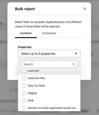 Boîte de dialogue Rejet en masse dans HubSpot qui montre un menu déroulant de sélection de propriétés avec des cases à cocher pour sélectionner jusqu’à trois propriétés à comparer en double.
