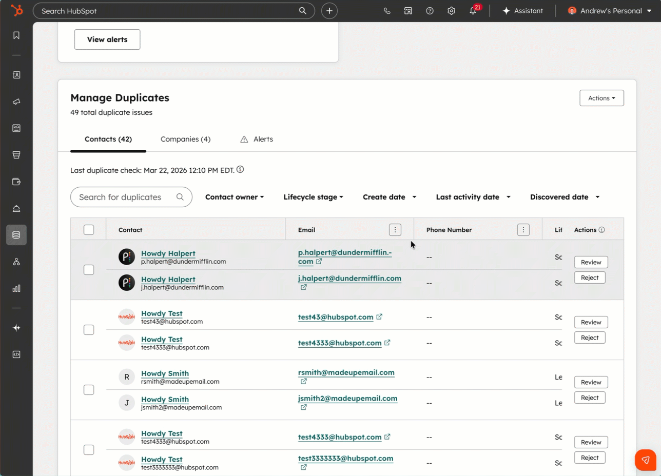 HubSpot Manage Duplicates dashboard showing a table of duplicate contact pairs with options to Review or Reject each set. Filters are present at the top of the table.