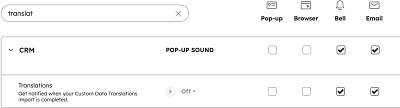 Una pantalla de ajustes de notificaciones de HubSpot con una búsqueda de "translat". El ajuste Traducciones es visible, mostrando que las notificaciones de Bell y Email se comprueban para completar la importación.