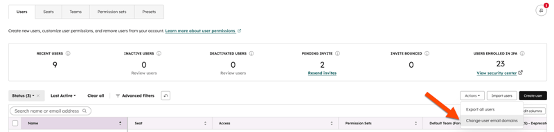 HubSpot Users settings with the Actions dropdown expanded, highlighting the Change user email domains option.