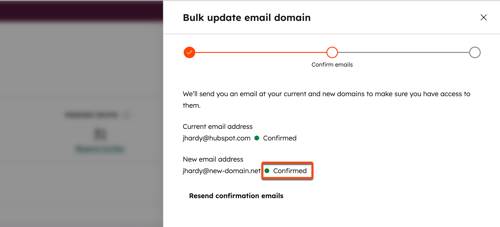 Bulk update email domain dialog in HubSpot with both current and new email addresses confirmed.