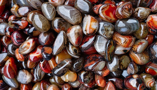 Many red, orange, and gray striped river rocks glistening.