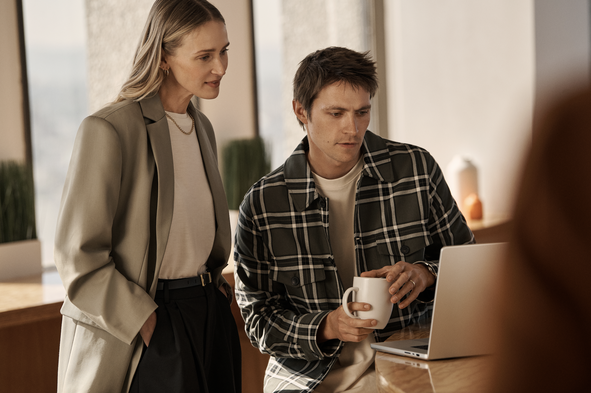 Eine Frau und ein Mann schauen auf einen Computer.