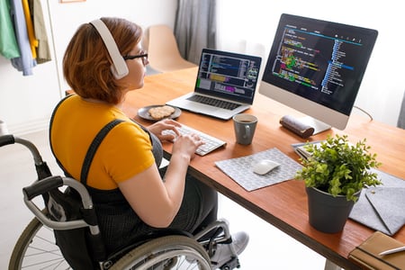 person sitting at a desk writing code on a desktop computer to align text in html 