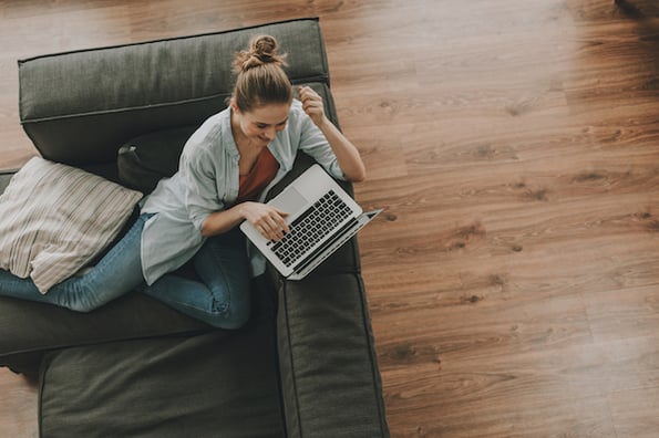 woman using a laptop on a couch to set custom domain names