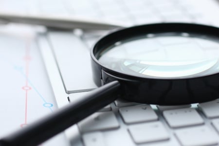 loupe sur un clavier, documents résultats audit