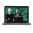 Two men posing confidently beside a green chalkboard background with chalk scribbles, featuring a pencil illustration and text in white chalk. The scene is displayed on an open laptop.