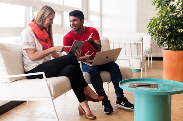 Two people working together on laptops