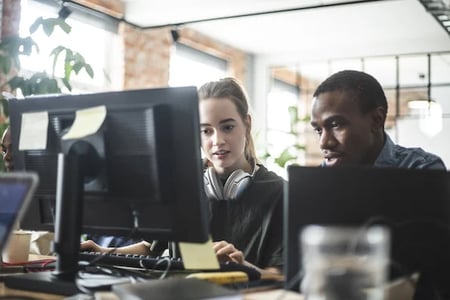 two developers measuring API response time on a computer