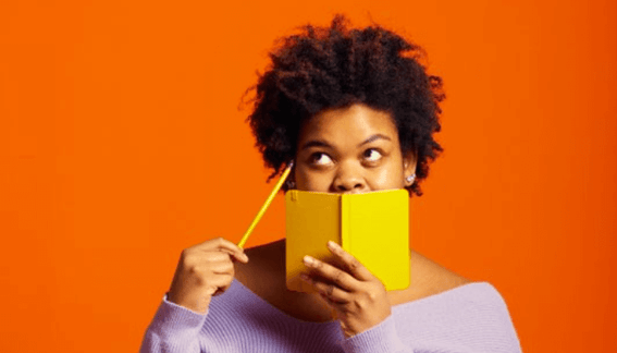 Frau mit Buch überlegt wie Chatbot erstellt