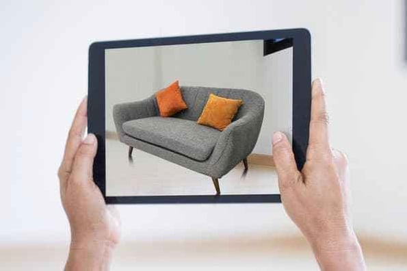 A person previews a couch with an AR product preview.