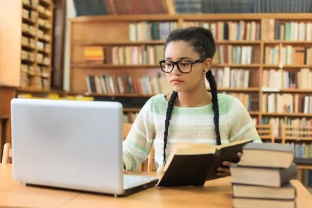 person finding a bookstore wordpress theme with a computer in a bookstore