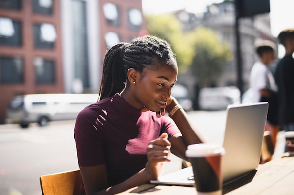 blogger naming her new blog using her laptop and drinking coffee