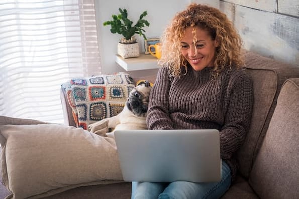 person sitting on a couch with a laptop creating a blog sidebar in wordpress