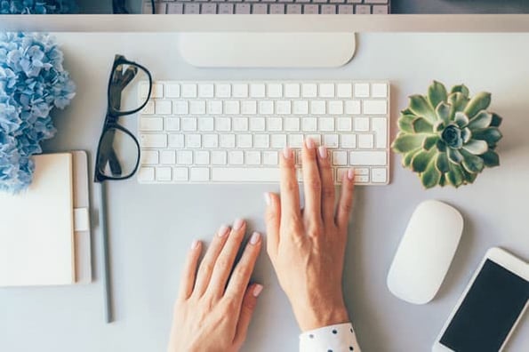 A person begins drafting a business blog after looking at stats that prove why the strategy is a worthy investment.