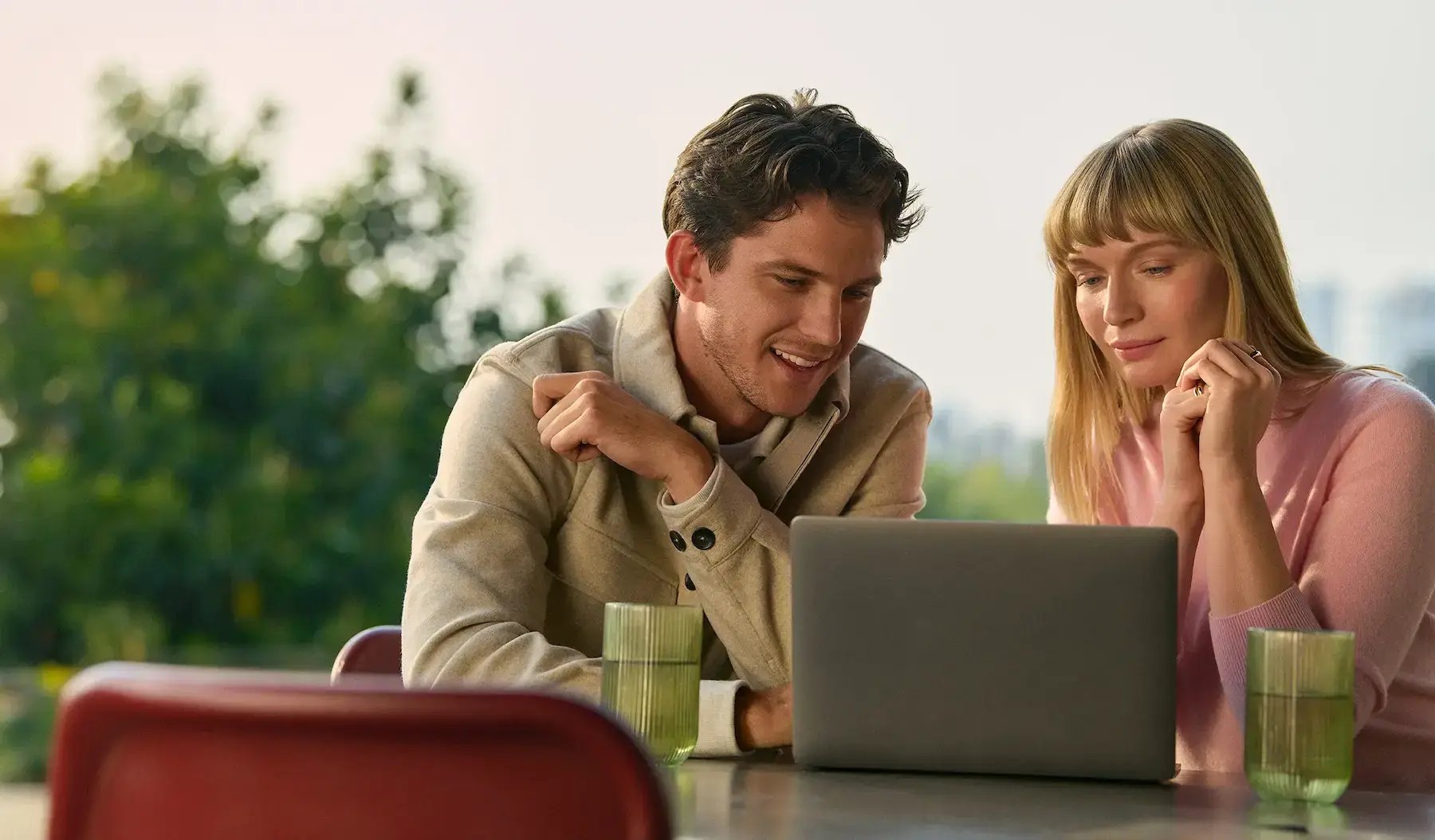 Zwei Teammitglieder analysieren gemeinsam Berichte auf einem Laptop