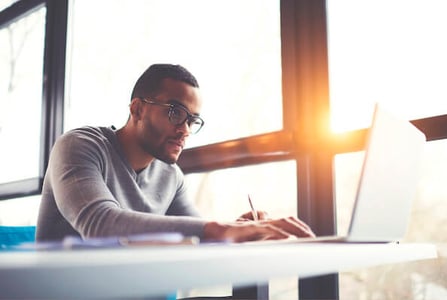 Man customizing WordPress login page using plugins on a laptop in an office