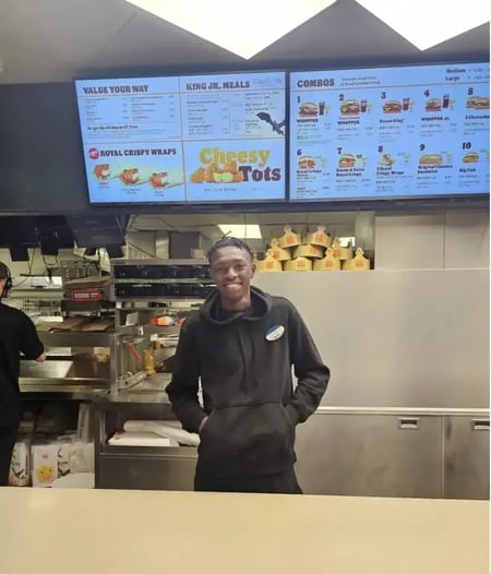 customer success care, mykale baker standing in front of the burger king branch he worked at to help his overwhelmed coworkers on his graduation day