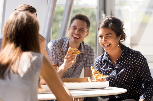 employees enjoying pizza astatine institution with bully leader branding