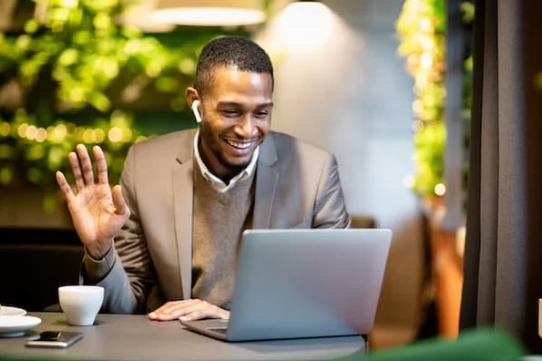 A business owner participates in a video call while making his usual physical services virtual.