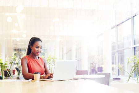 Businesswoman in a modern office using her laptop for GraphQL vs. REST API
