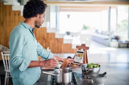 person using a wordpress food blog theme on their tablet while cooking 