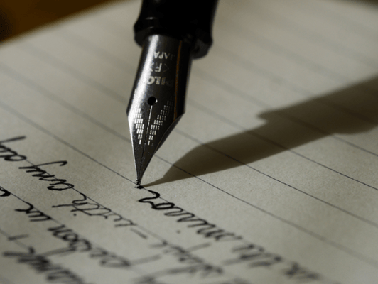 stylo plume écrivant sur un papier