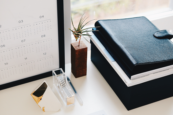 Arbeitstisch mit Büroutensilien und einer geöffneten Kalender-App