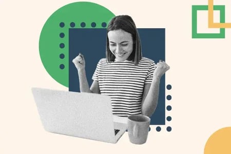 A woman pumps her fist while working at a laptop