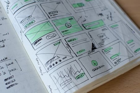 Photo of a grid of hand-drawn wireframes.