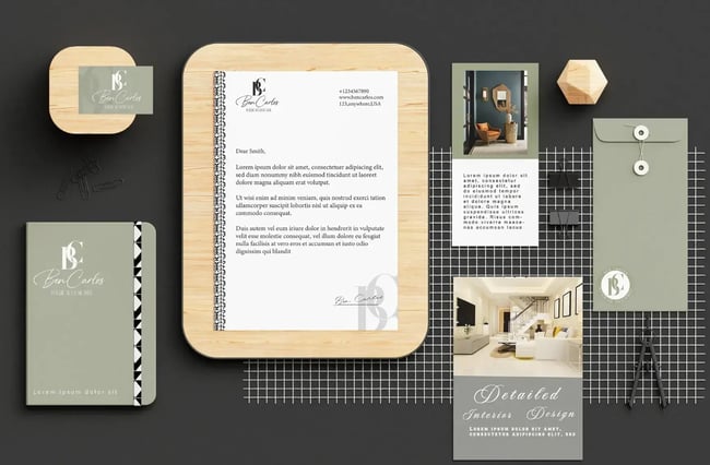 Ben Carlos interior design branding on light wood background with minimalist sage green elements