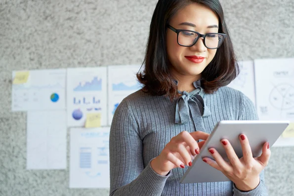 A woman browses LinkedIn on her tablet for B2B marketing purposes.