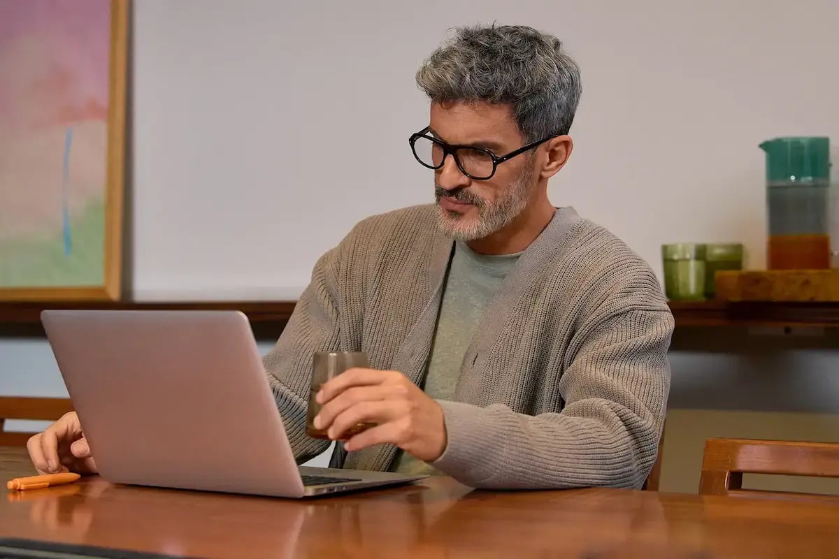 Mann mit Brille arbeitet konzentriert am Laptop