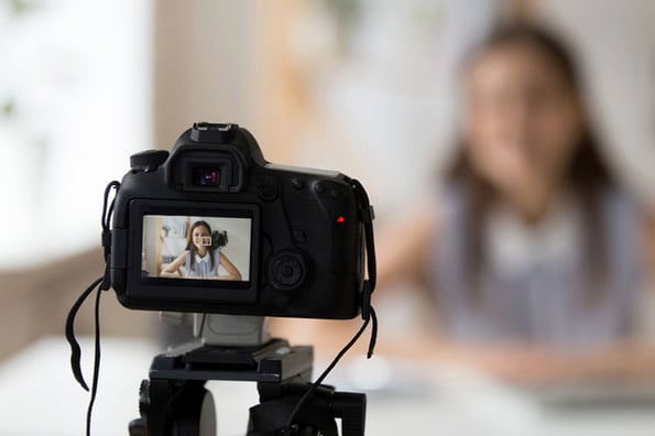 A woman films a marketing video remotely from her own home.