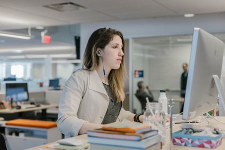 mulher na frente do computador estuda maneiras de implementar um CRM na empresa 
