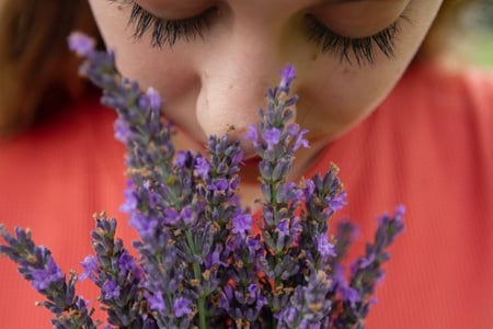 femme sentant un bouquet de fleurs