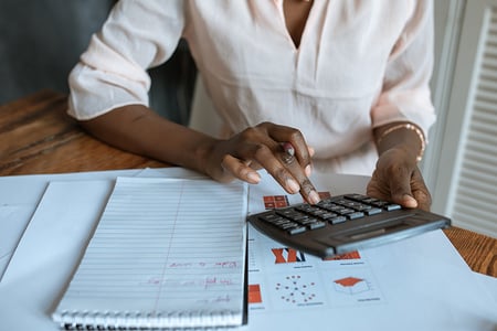 Femme entrain de faire des calculs sur sa calculatrice