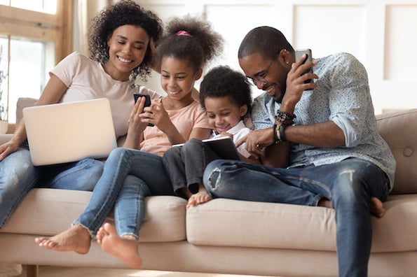 a family sitting on a couch using a computer to browse for a multipurpose wordpress theme