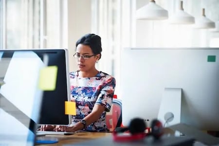 woman using a computer to review why not to use nulled wordpress themes and plugins